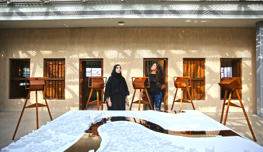 Due donne osservano un tavolo espositivo di un museo.